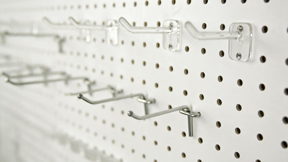 Amoowis metal pegboard panel showing 1/4 inch hole pattern with assorted hooks installed